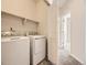 Functional laundry room equipped with a washer, dryer, and convenient overhead shelving at 600 E Dry Creek Pl, Littleton, CO 80122