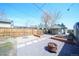 Spacious backyard includes a wooden fence, gravel, garden beds, and a fire pit at 3735 Inca St, Denver, CO 80211