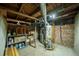 Basement utility area featuring a water heater, brick walls, and exposed wooden beams at 3735 Inca St, Denver, CO 80211
