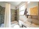 Bathroom features tiled shower and tub, vanity, with a window for natural light, and a wooden door at 3735 Inca St, Denver, CO 80211