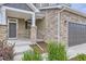 Inviting front porch with stone columns and manicured landscaping at 4433 N Picadilly Ct, Aurora, CO 80019