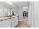 Bathroom with dual sinks, granite countertops, and a view into the walk-in closet at 3344 Evening Pl, Castle Rock, CO 80109