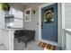 Welcoming front porch with a blue door adorned with a wreath, complemented by a cozy seating area and stylish welcome mat at 3344 Evening Pl, Castle Rock, CO 80109