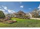 Charming exterior of home with beautiful landscaping, stone accents and lush green lawn under a cloudy blue sky at 8392 Niwot Meadow Farm Rd, Niwot, CO 80503