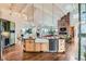 Bright, open kitchen featuring an island with a farmhouse sink and views of the living space and fireplace at 8392 Niwot Meadow Farm Rd, Niwot, CO 80503