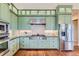 Charming kitchen with green cabinets, stainless steel appliances, and hardwood floors, offering a blend of style and functionality at 8392 Niwot Meadow Farm Rd, Niwot, CO 80503