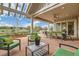 Relaxing covered patio with outdoor seating, a dining area, and a built-in grill overlooking a green field at 8392 Niwot Meadow Farm Rd, Niwot, CO 80503