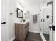 Bathroom featuring a modern vanity with black hardware, glass shower door, and sleek design at 7320 W 21St Ave, Lakewood, CO 80214