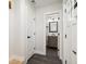 Hallway featuring dark floors that lead to a bathroom with modern gray vanity and toilet at 7320 W 21St Ave, Lakewood, CO 80214