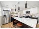Beautiful kitchen with white countertops, dark cabinets, stainless steel appliances, and modern pendant lights at 7320 W 21St Ave, Lakewood, CO 80214