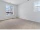 Bright, sunlit bedroom with neutral carpet and paint and a large window overlooking a snow-covered landscape at 9153 Truckee Ct, Commerce City, CO 80022