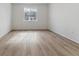 Spacious room with hardwood floors, a large window offering plenty of natural light, and neutral walls at 9153 Truckee Ct, Commerce City, CO 80022