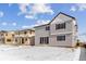 A gray two-story home featuring large sliding glass doors and black-trimmed windows set against a snowy landscape at 9153 Truckee Ct, Commerce City, CO 80022