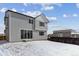 A gray two-story house featuring large sliding glass doors and black-trimmed windows set against a snowy landscape at 9153 Truckee Ct, Commerce City, CO 80022