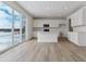 Modern kitchen features white cabinets, stainless appliances, an island, and sliding glass doors to the outside at 9153 Truckee Ct, Commerce City, CO 80022