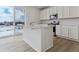 Modern kitchen featuring white cabinets, stainless steel appliances, quartz countertops, and large windows at 9153 Truckee Ct, Commerce City, CO 80022