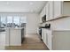 Bright kitchen with stainless steel appliances, white cabinetry and countertops, an island, and natural wood-look flooring at 9153 Truckee Ct, Commerce City, CO 80022