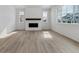 Elegant living room with wood floors, a modern fireplace, and large windows providing ample natural light at 9153 Truckee Ct, Commerce City, CO 80022