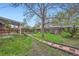 Backyard featuring garden beds, green grass, brick pavers, and a covered patio at 1740 S Estes St, Lakewood, CO 80232