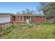 Charming brick home with a well-manicured front yard and white-trimmed windows; garage attached at 1740 S Estes St, Lakewood, CO 80232