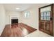 Cozy living room featuring hardwood floors, a brick fireplace, and a classic wooden door at 1740 S Estes St, Lakewood, CO 80232