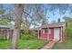 Cozy outbuilding with a red exterior, white trim, and a quaint walkway in a grassy backyard setting at 1740 S Estes St, Lakewood, CO 80232
