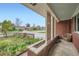 Cozy covered porch with patterned brickwork and lattice details, offering a peaceful outdoor seating area at 1740 S Estes St, Lakewood, CO 80232