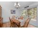 Traditional dining room with wooden table, chairs, chandelier, and sliding door with a natural light source at 649 Cottonwood Dr, Evergreen, CO 80439