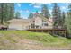 Exterior view of a home with a spacious deck, set amidst a lush wooded landscape at 649 Cottonwood Dr, Evergreen, CO 80439