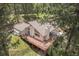 Aerial view of a multi-story home featuring a spacious deck, nestled among lush trees at 649 Cottonwood Dr, Evergreen, CO 80439