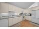 Functional kitchen with white cabinets, tile countertops, modern appliances, and hardwood floors at 649 Cottonwood Dr, Evergreen, CO 80439