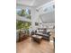 Open-concept living room with large windows with forest views, hardwood floors, and access to kitchen and dining areas at 649 Cottonwood Dr, Evergreen, CO 80439