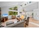 Spacious living room featuring large windows with forest views, hardwood floors, and comfortable furnishings at 649 Cottonwood Dr, Evergreen, CO 80439