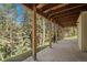 Covered patio area offers a serene space to relax and enjoy the scenic wooded backdrop at 649 Cottonwood Dr, Evergreen, CO 80439