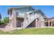 View of the home's exterior, showcasing a multi-level deck and a grassy backyard at 7852 S Addison Way, Aurora, CO 80016