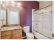Bright bathroom featuring a tub with glass doors, a toilet, and a vanity with a granite countertop at 7852 S Addison Way, Aurora, CO 80016