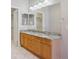 Bathroom with double vanity featuring a granite countertop and warm wood cabinetry at 7852 S Addison Way, Aurora, CO 80016