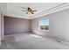 Large bedroom featuring tray ceiling, a bright window with a view, and neutral carpeting at 7852 S Addison Way, Aurora, CO 80016