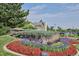 Inviting community entrance sign surrounded by colorful flowerbeds and lush landscaping at 7852 S Addison Way, Aurora, CO 80016