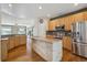 Open kitchen with stainless steel appliances, granite counters, and hardwood floors at 7852 S Addison Way, Aurora, CO 80016
