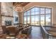 Elegant lounge area with a cozy fireplace, comfortable seating, and expansive windows at 7852 S Addison Way, Aurora, CO 80016