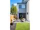This backyard features artificial turf, a modern gray exterior, a patio with seating, and stone landscaping at 2321 S Acoma St, Denver, CO 80223