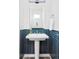 Bathroom featuring pedestal sink, blue subway tile wainscoting, white walls, and modern lighting at 2321 S Acoma St, Denver, CO 80223