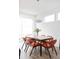 Bright dining room features stylish mid-century modern furniture, a vase of tulips, and oversized lighting fixture at 2321 S Acoma St, Denver, CO 80223