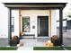 Stylish front porch showcasing a sleek black door, modern planters, and a welcoming striped doormat at 2321 S Acoma St, Denver, CO 80223