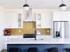 Well-lit kitchen features stainless steel appliances, modern cabinetry, a kitchen island, and a unique yellow backsplash at 2321 S Acoma St, Denver, CO 80223