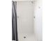 Modern shower with tiled walls and a gray shower curtain, creating a minimalist space at 2321 S Acoma St, Denver, CO 80223