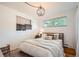 Bright bedroom featuring large window, decorative wall hanging, and a comfortable bed with plush pillows at 7491 W 45Th Ave, Wheat Ridge, CO 80033