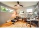 This cozy bedroom includes gleaming hardwood floors, two windows, and a comfortable chair and desk setup at 7491 W 45Th Ave, Wheat Ridge, CO 80033