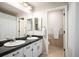 Bathroom featuring dual sinks with black countertops and a separate toilet area at 17926 E Berry Ave, Centennial, CO 80015